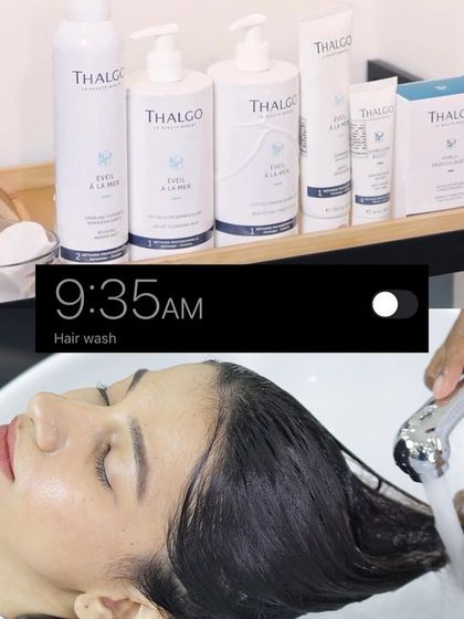 The day begins with a moment of pure relaxation. At 9:35 AM, a client enjoys a gentle hair wash using premium Thalgo products to prepare for her treatment.