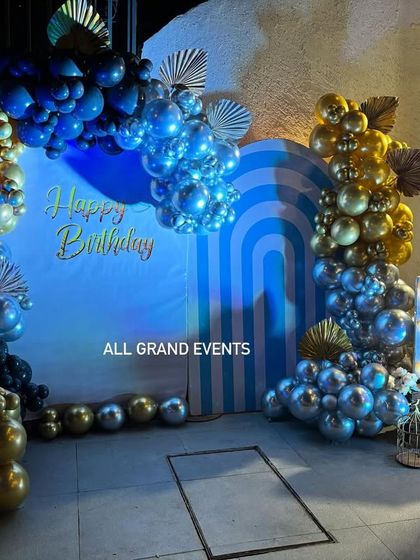 A detailed shot of the blue and gold balloon arrangement, showing the mix of metallic and matte balloons that add texture and visual interest.