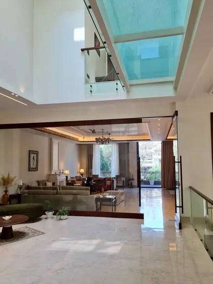 Another angle of the double height foyer, emphasizing the scale and the flow of light from the skylight. The design is not just built, it is sculpted.