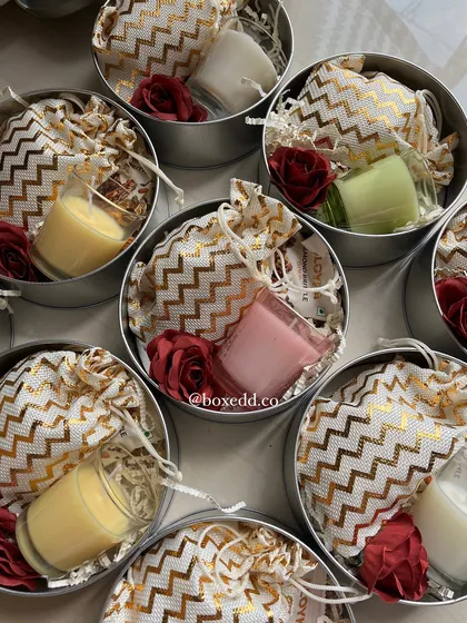 A peek inside the return favour tins, revealing small scented candles and treats packed in a decorative potli bag.