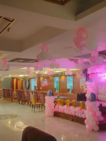 A wide view of the banquet hall decorated for the first birthday, showing the stage and guest seating area.