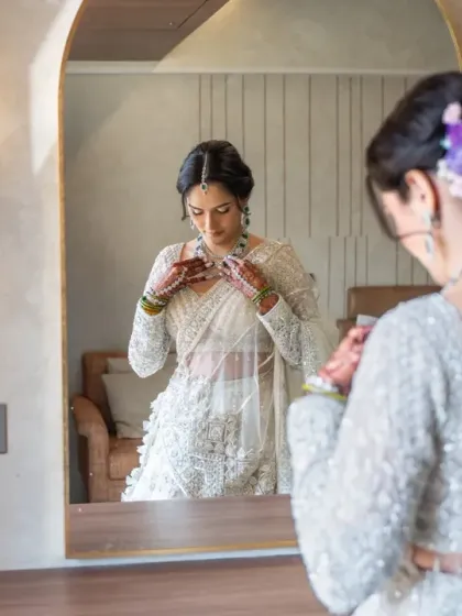 A candid moment of the bride putting on her jewelry, captured via her reflection. It's these small details that help tell the full story of the wedding day.