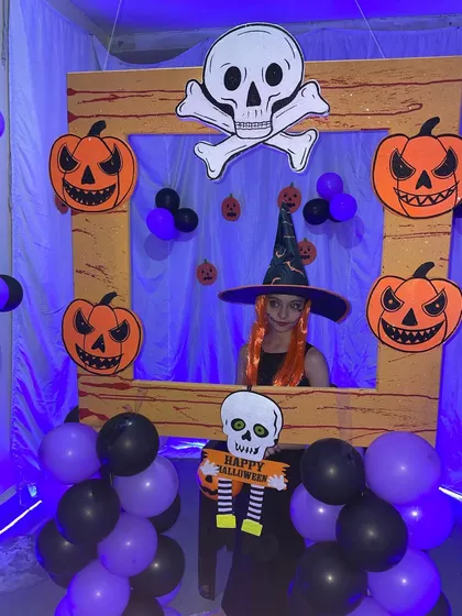 The Halloween photo booth is perfect for kids to show off their costumes. Here, a guest with a witch hat and orange hair gets her picture taken.