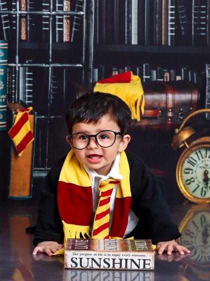 This little wizard is ready for his studies, with a book of "Sunshine" and a look of pure happiness. The round glasses complete the iconic look.