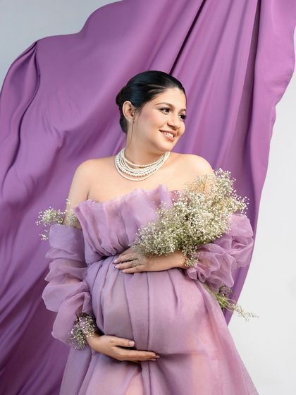 A vision in lavender. This portrait uses a flowing lavender fabric in the background to add a sense of drama and movement, perfectly complementing the delicate organza gown.