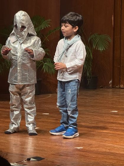 An alien and a boy share a scene on stage, a great example of how our drama classes encourage imagination and creative interaction.