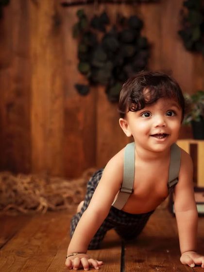 Here is 'Mr. Onederful' himself. This rustic setup with hay and wooden crates is perfect for a charming and classic first birthday portrait.