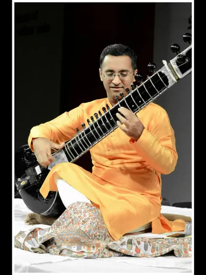 Performing in an orange kurta for a morning concert at a school.