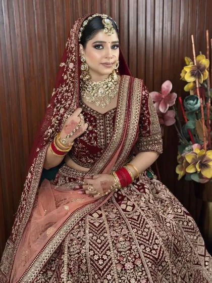 A full-length shot of the bride in her maroon velvet lehenga, showing how the complete look comes together with grace and elegance.