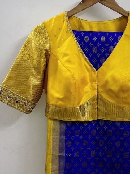A close-up of the matching blouse for Priya's saree, showing the beautiful brocade work on the sleeves.