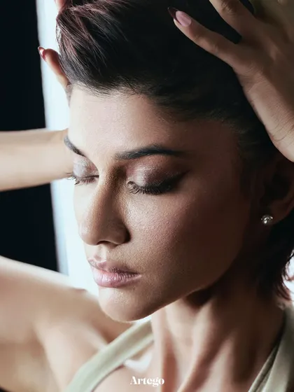 A serene beauty portrait from the Artego Magazine feature, with soft backlighting highlighting the model's profile and hair texture.