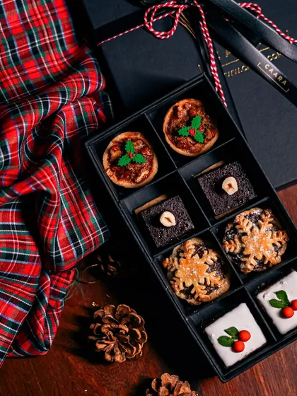 Our eight-piece Christmas sweet box, set against a festive tartan background. It's a perfect small gift or a wonderful treat to share with a loved one during the holidays.