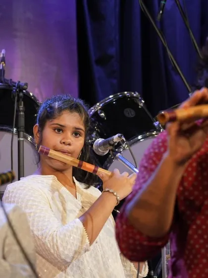 A student demonstrates proper hand positioning on the bansuri, a key focus in our instrumental classes.