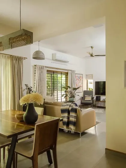 This view from a renovated home shows how I approach existing structures. By replacing old windows with larger sliding units, we increased natural light by 50 percent, seamlessly merging the dining and living areas with the greenery outside and transforming the home's atmosphere.