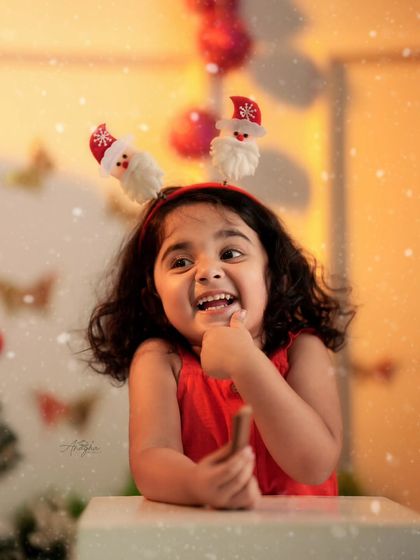 A close-up shot of a happy toddler wearing a cute Santa headband. These expressive, candid shots are often the most cherished ones.