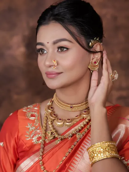 A classic portrait showcasing the flawless base and the traditional gold jewelry.