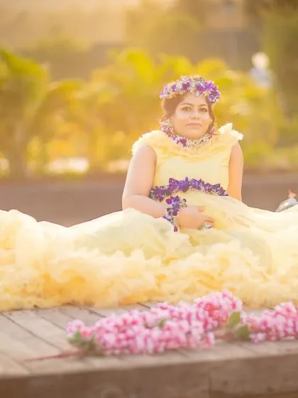 A dreamy, sun-drenched photo with the mom-to-be sitting amidst a sea of yellow fabric and surrounded by flowers.