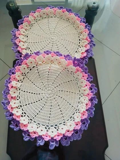 This pair of placemats uses shades of purple, pink, and white for its floral border, creating a soft and romantic feel.