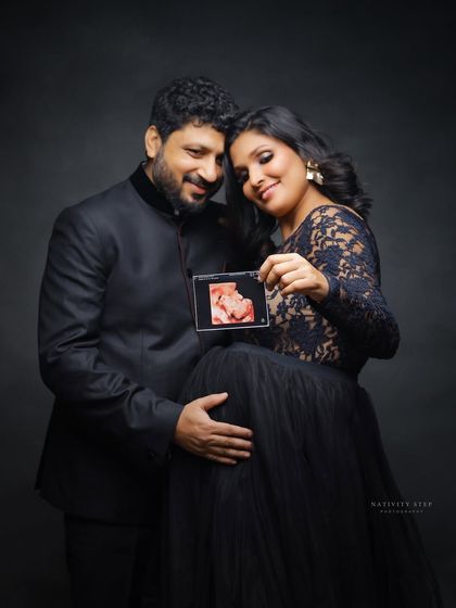 A beautiful way to include the baby's first picture. The couple holds up an ultrasound image, making the baby a central part of the portrait.