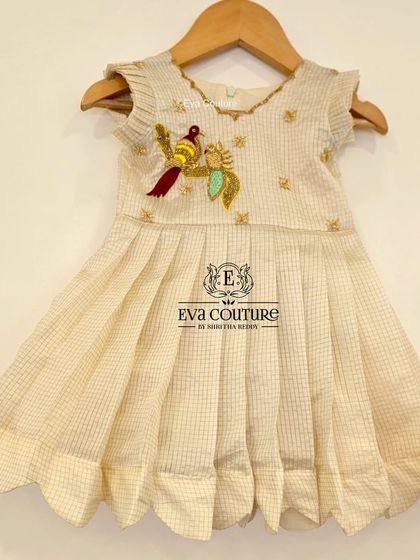 The same bird-embroidered frock in a classic off-white, ready to ship for little ones.