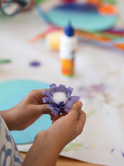 Here, a child is crafting a delicate paper flower. My classes cover a wide range of crafts, not just painting. We explore paper art, sculpture, and mixed media to keep things exciting and help kids discover new passions.