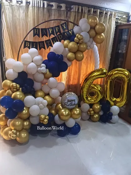 Celebrating 60 years with a classic color combination. This balloon arrangement in gold, navy, and white around a circular frame creates a sophisticated backdrop for a 60th birthday party.