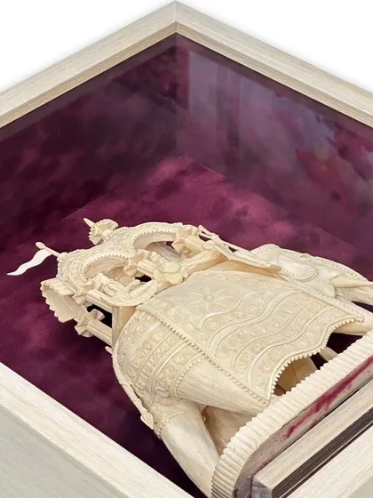 An overhead view showing the depth of the shadow box for the Sholapith elephant. The bordeaux suede matboard creates a rich, luxurious backdrop that makes the delicate, light-colored wood carving stand out.