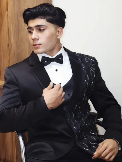 This is a unique black tuxedo jacket with textured, asymmetrical lapel detailing. It’s a bespoke piece for a client who wanted a modern twist on a classic formalwear staple.