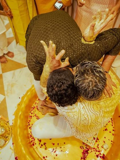 An aerial view of the groom being hugged by a friend in the middle of the haldi ritual.