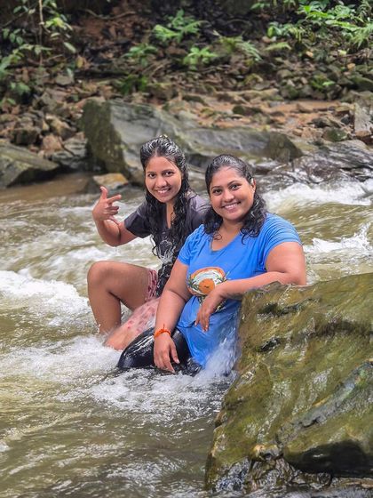 Two friends enjoying a refreshing dip in a stream on the way to Bandaje Falls.