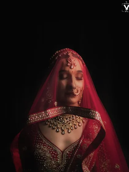A bridal portrait that is pure poetry, using the vibrant red veil to frame a moment of quiet contemplation. We see the bride not just as a subject, but as the central character in a beautiful story, and we photograph her with the artistry she deserves.
