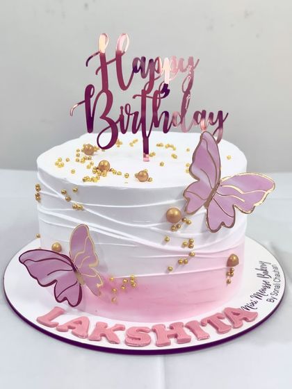 A classic butterfly theme cake. The soft pink ombre, delicate white texture, and elegant butterfly toppers make this a timeless choice for a birthday.