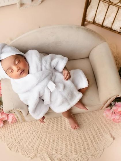 Can you believe she is just 10 days old? This little darling rocked every pose like a boss, especially in this adorable spa day setup with a tiny bathrobe and floral accents.