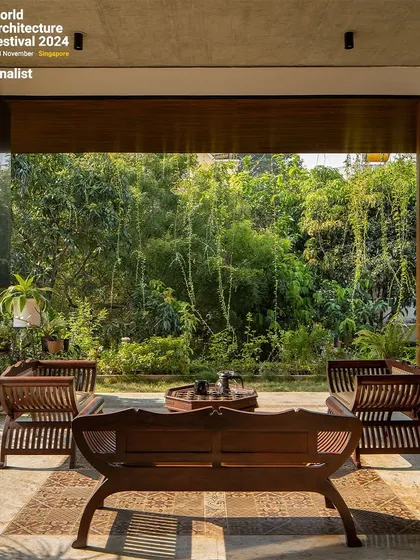 Another view of the patio, emphasizing the clean lines of the wooden furniture and the rich texture of the natural stone flooring.