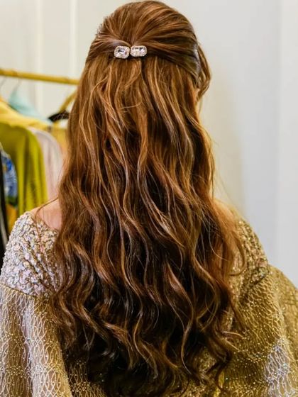 A simple half-up twist with soft waves is a timeless and elegant choice. The sparkling clip adds just the right amount of glamour.