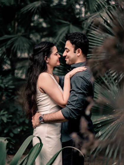 A classic romantic pose amidst dense green foliage. The natural environment creates a sense of seclusion, allowing the couple's connection to be the focus.