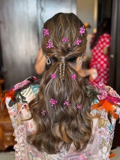 A complete view of this effortlessly chic low ponytail, showing how the flowers are scattered for a natural, garden-like effect.