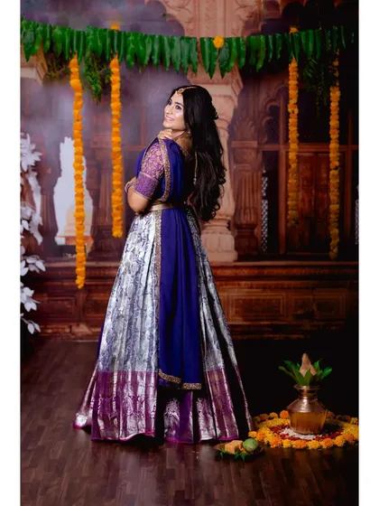 Embrace tradition with this stunning purple and silver half saree. The intricate gold embroidery on the blouse adds a touch of royalty, making it perfect for engagements, festivals, or any ethnic celebration.