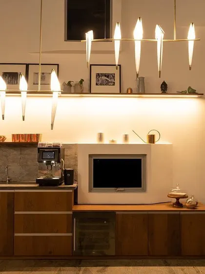 A closer look at the pantry area, where the layered lighting is clear. The decorative bird lights provide visual interest, while the integrated strip light illuminates the countertop for making coffee or preparing snacks.