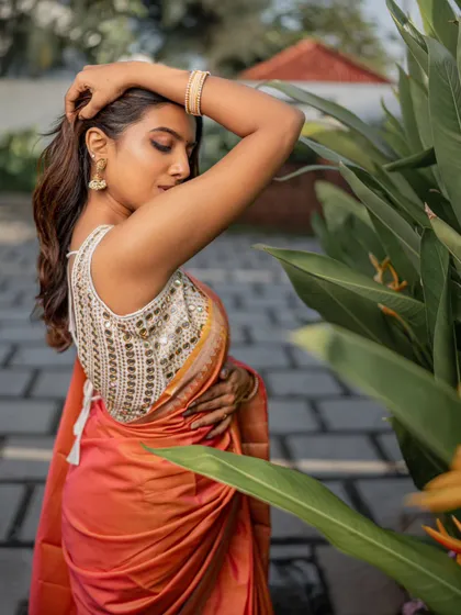 A stunning shot from a creative saree shoot. The makeup is kept warm and glowing to match the beautiful sunset-hued saree.