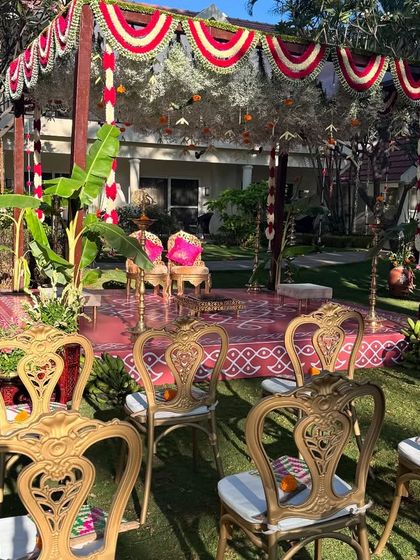 A beautiful garden wedding setup with a traditional mandap. The elegant gold chairs and vibrant floral decor create a perfect blend of tradition and celebration.