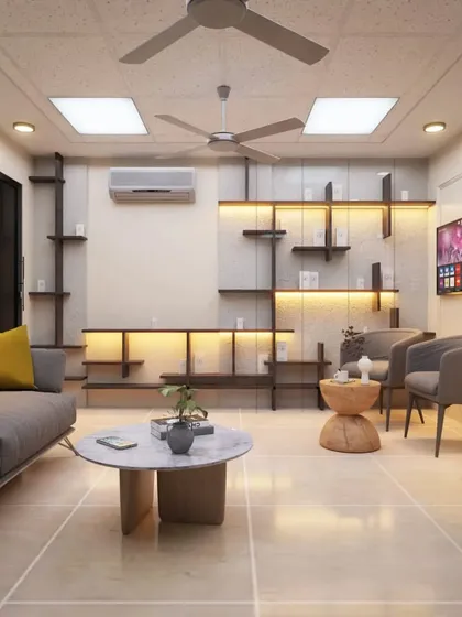 A comfortable and modern living room or waiting lounge concept. The design features a unique backlit shelving unit, a neutral color palette with pops of yellow, and a mix of ceiling lights to create a warm and inviting space.