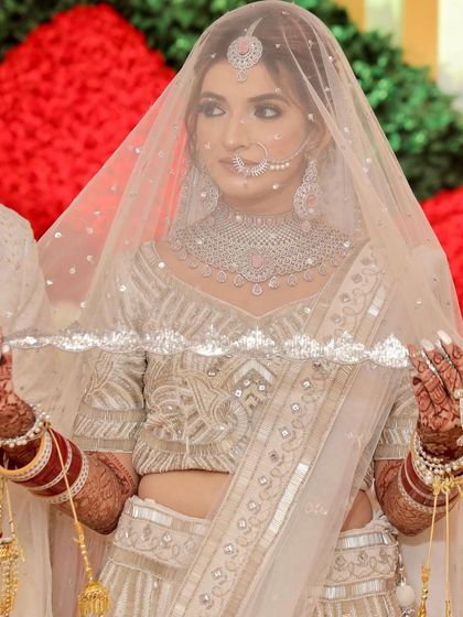 The bride under her veil. This classic shot is all about grace and elegance, with her soft makeup peeking through the delicate fabric.