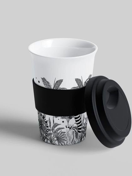 Another view of the Madagascar-themed coffee cup. The monochrome jungle print wraps around the surface, making it a stylish and artistic accessory.