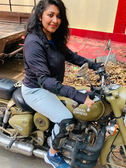 A graduate poses confidently on her Royal Enfield. She is a perfect example of how our training empowers women to own the road.