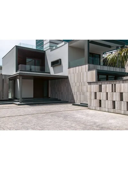 A wide shot of the Rosewood Farmhouse driveway and entrance. The design uses a mix of materials and volumes to create a grand yet welcoming first impression, setting the tone for the modern luxury within.