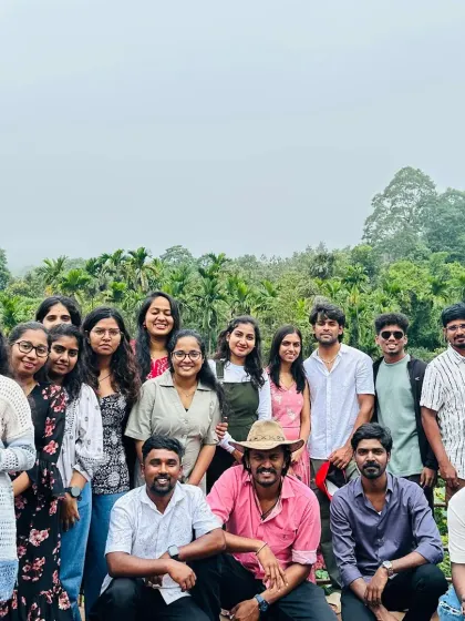 A group enjoying the pleasant weather and greenery at a homestay surrounded by palm trees.