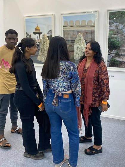 More visitors engaging with artist Surekha about her work at Art Mumbai.