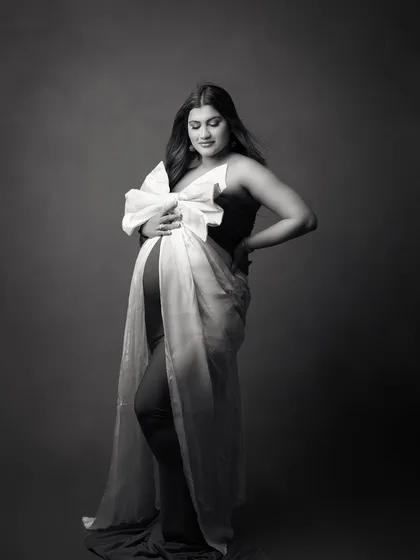 The same festive maternity look, captured in a timeless black and white portrait. This highlights the emotion and form, creating a classic, artistic image of the mother-to-be.
