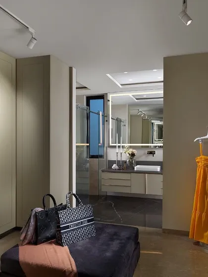 A walk-in closet designed for both style and function. This "His & Her" space features open shelving and custom cabinetry, leading seamlessly into the master bathroom, creating a luxurious and practical dressing suite.